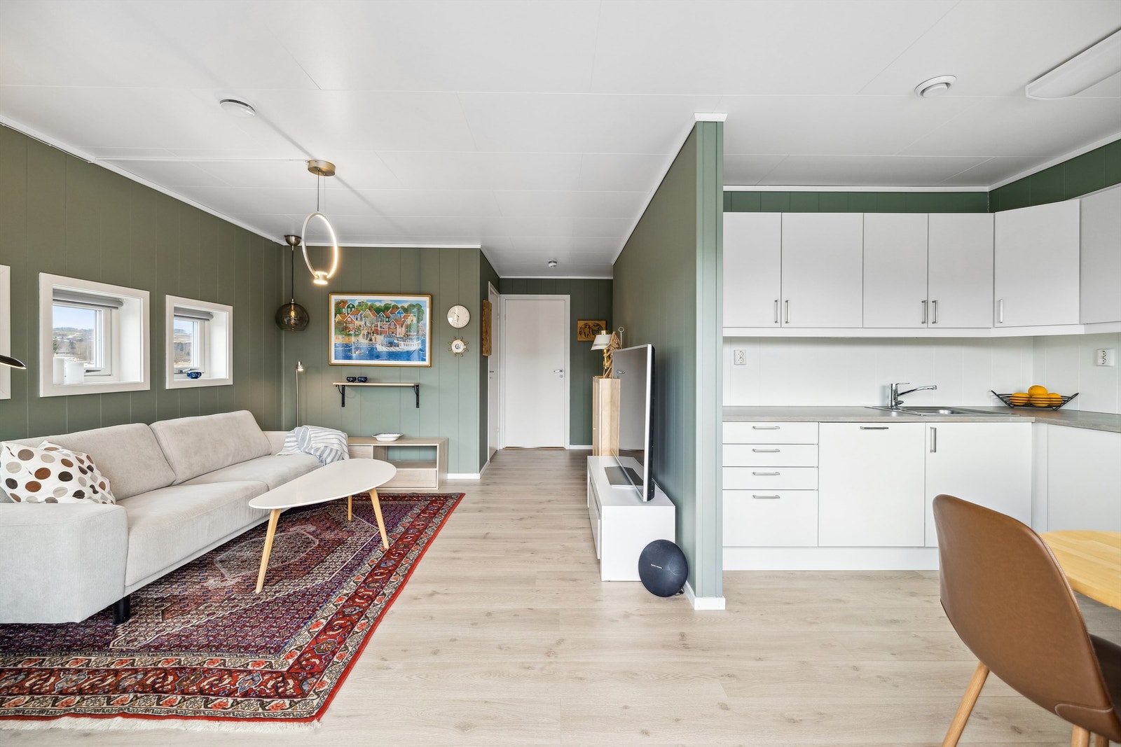 Den åpne stue- og kjøkkenløsningen gir et sosialt preg, med store vindusflater som slipper inn godt med naturlig lys. Galleribilde