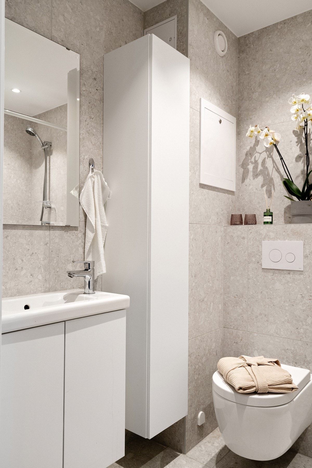 Innredet med servant, benkeskap, speil, høyskap og vegghengt toalett. Galleribilde