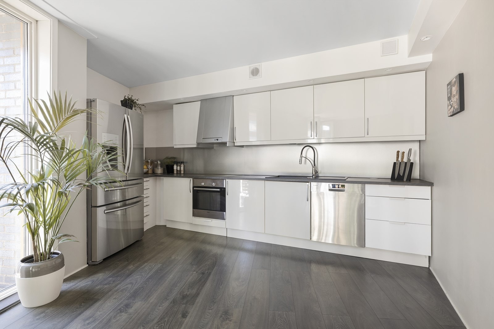 Moderne kjøkken med masse skap- og benkeplass Galleribilde