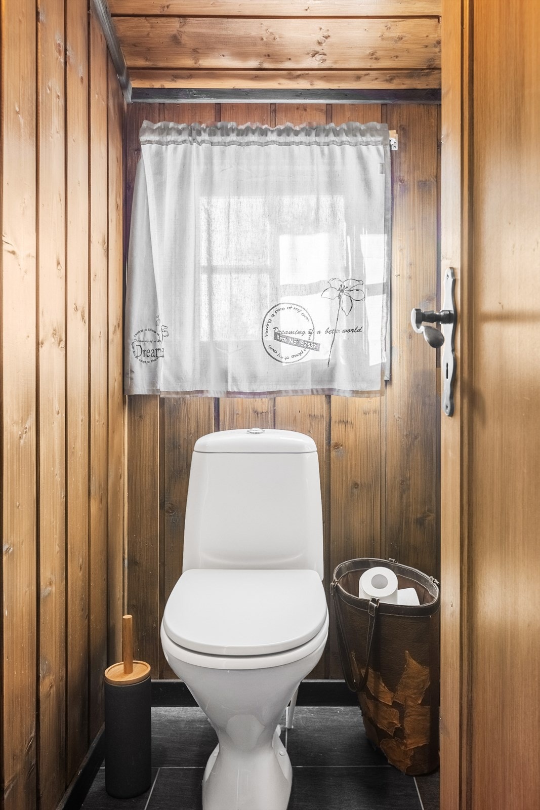 Det er to toalettrom i hytta, begge med fliser på gulvet og panel på veggene. Galleribilde