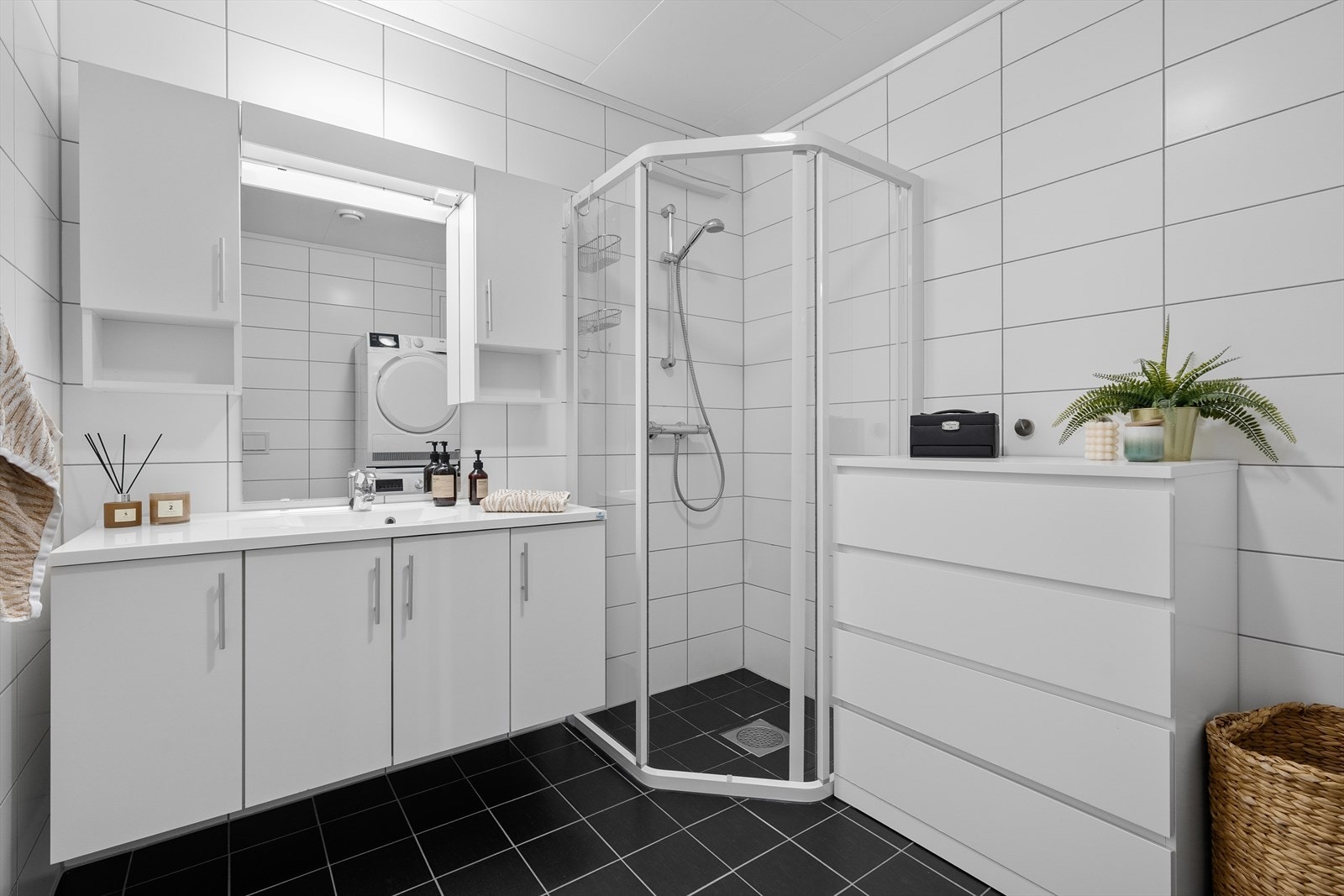 På badet har du god plass til oppbevaring i innredningen, og ellers er det servant i innredningen, dusjhjørne, toalett og opplegg for vaskemaskin og tørketrommel. Galleribilde