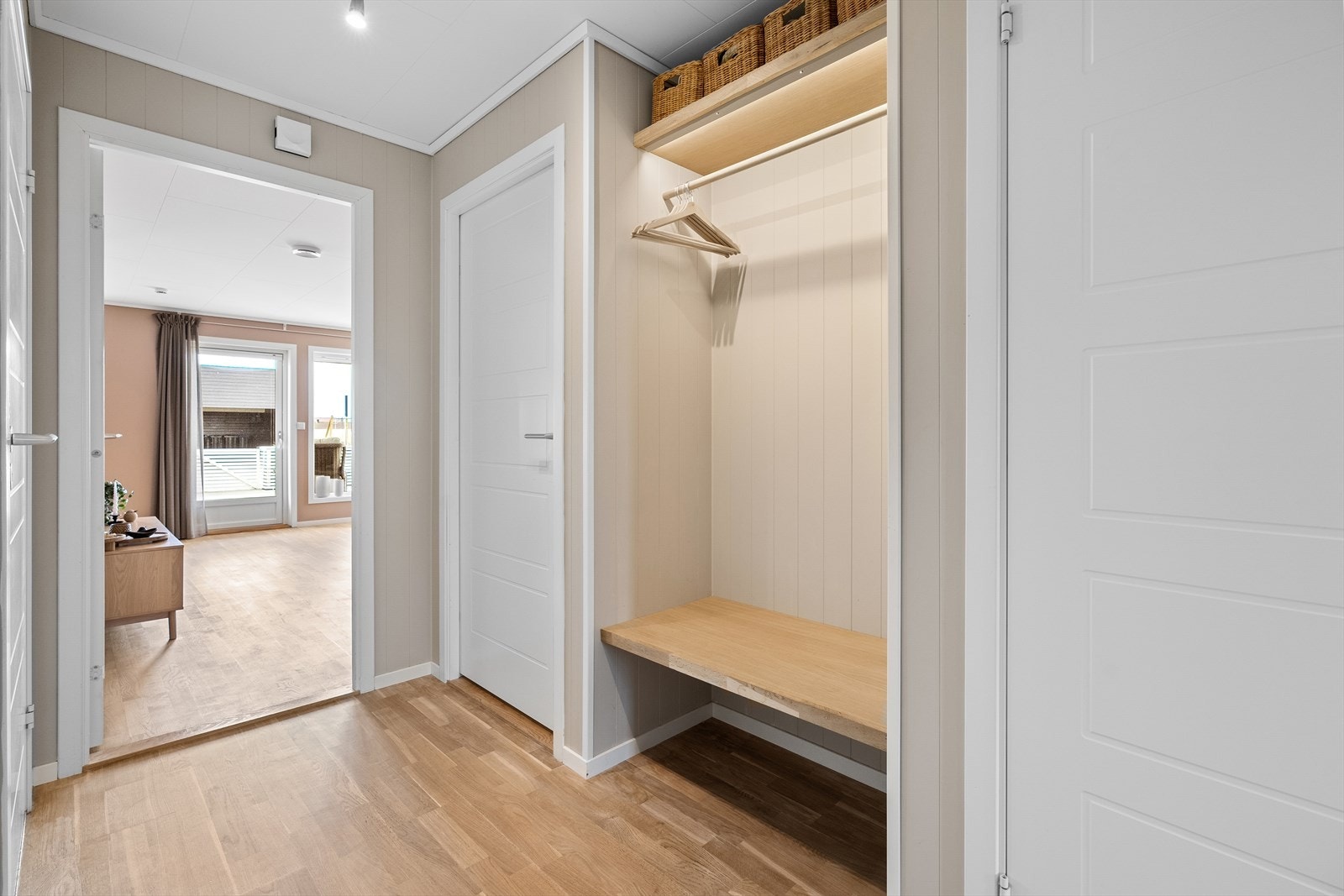 Gangen er avlang med ett "innhukk" for en naturlig plassering av garderobeskap/ evt. oppheng og oppbevaring av sko og yttertøy. Her er det laget til med benk og oppheng for yttertøy. Galleribilde