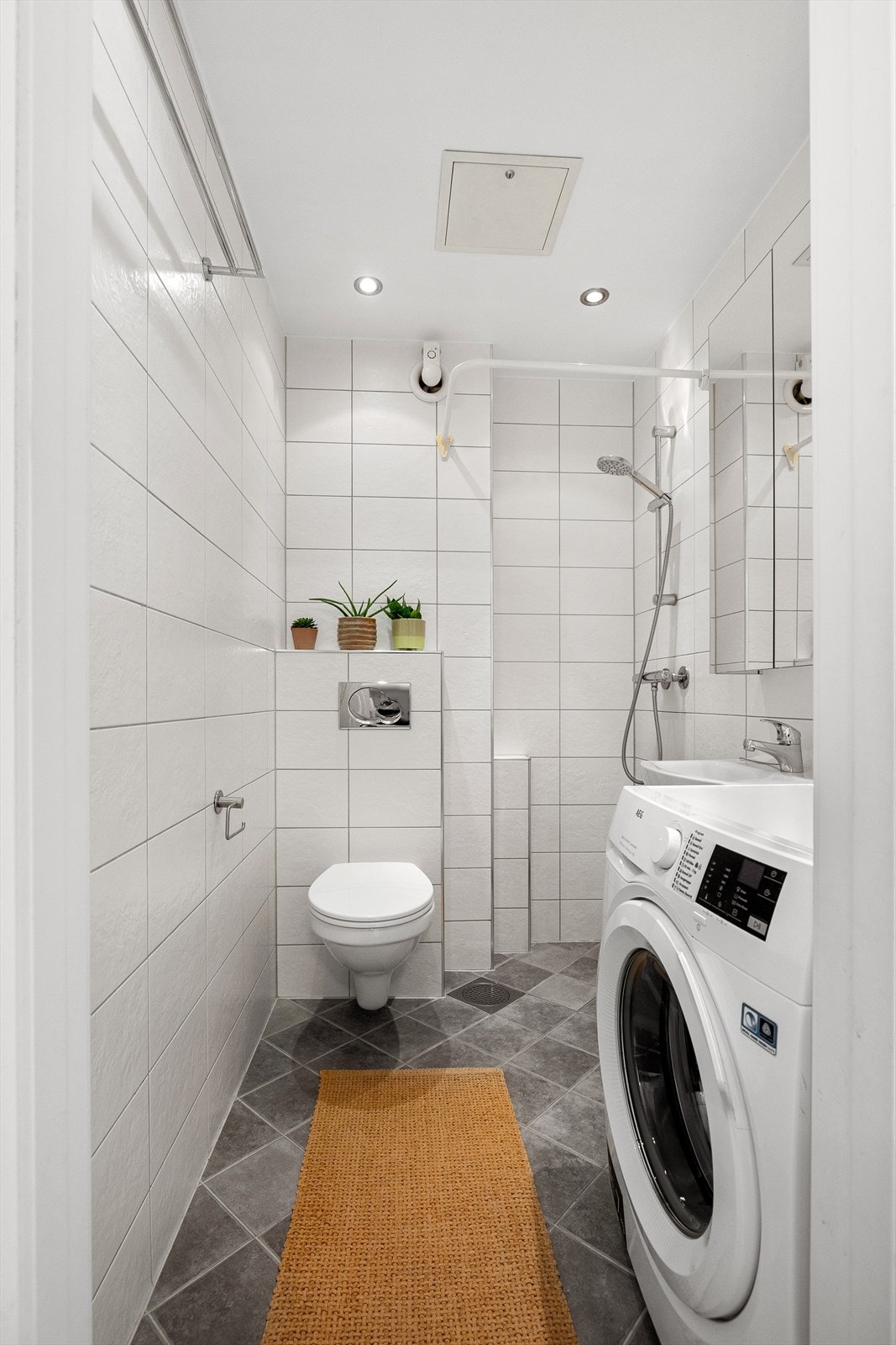 Pent flislagt baderom med varme i gulv og opplegg for vaskemaskin Galleribilde