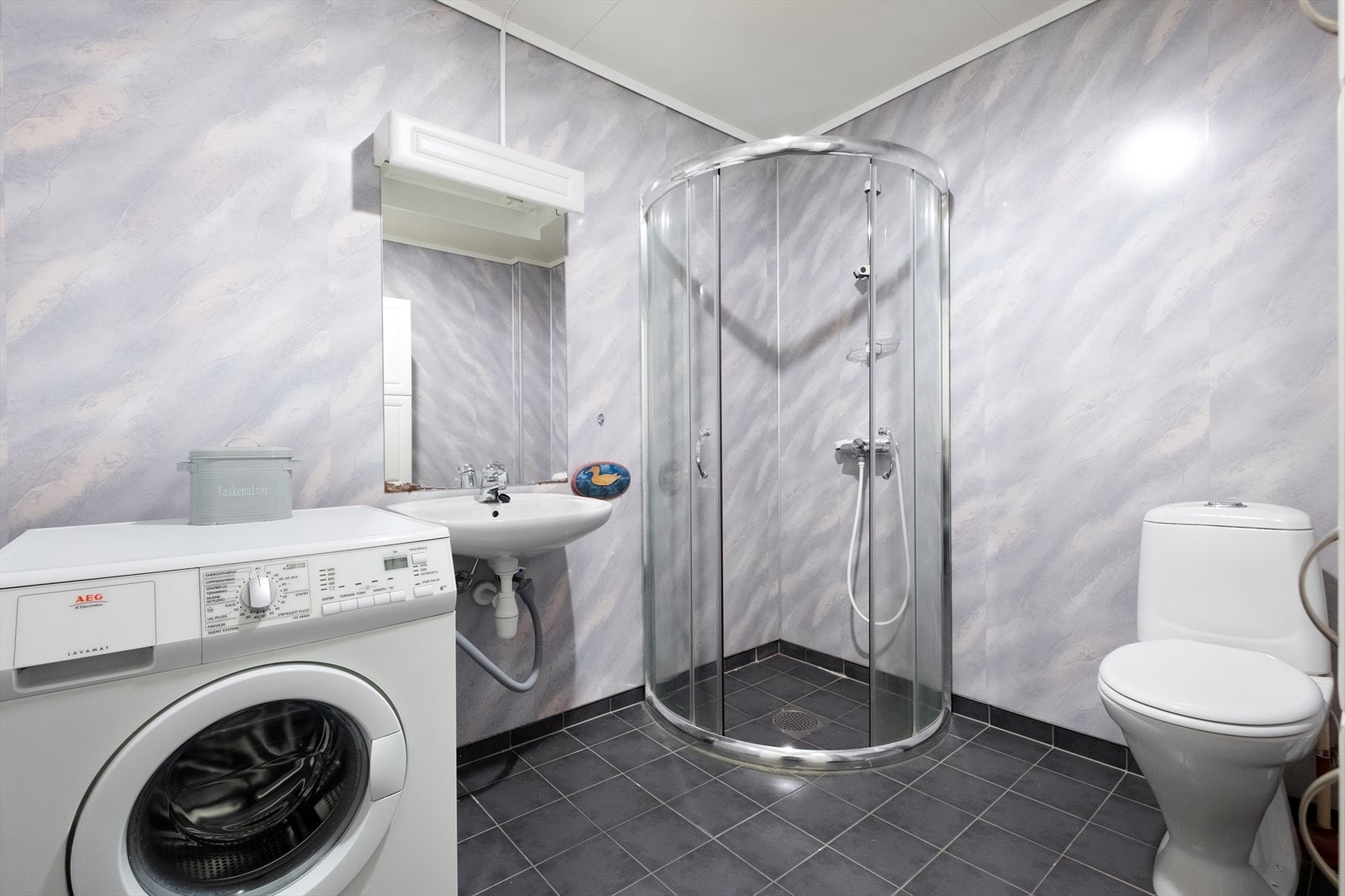 Badet har flislagt gulv med gulvvarme. Galleribilde