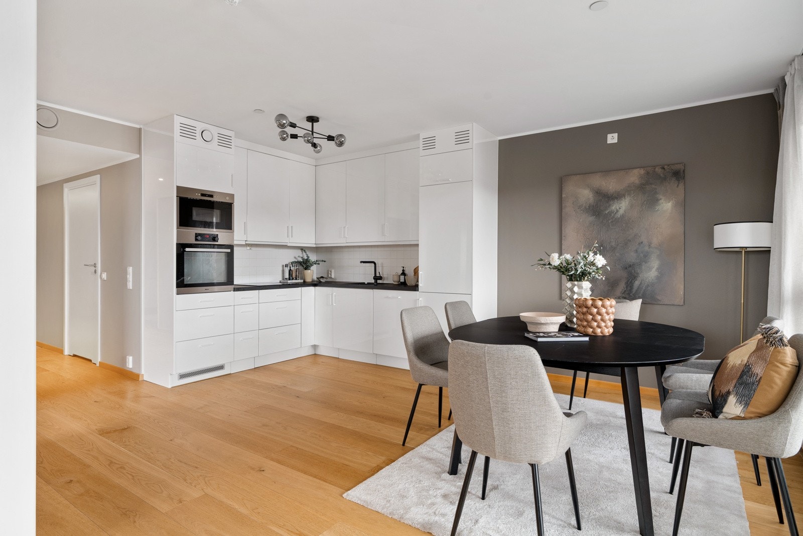 Tidløst kjøkken med lyse fronter og mørk benkeplate som setter en fin kontrast. Galleribilde