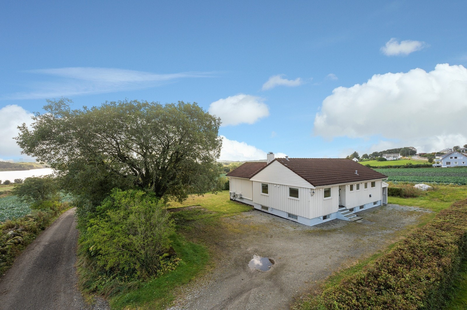 Fasade og oppstillingsplass til flere biler - Med vei ned til stokkavannet Galleribilde