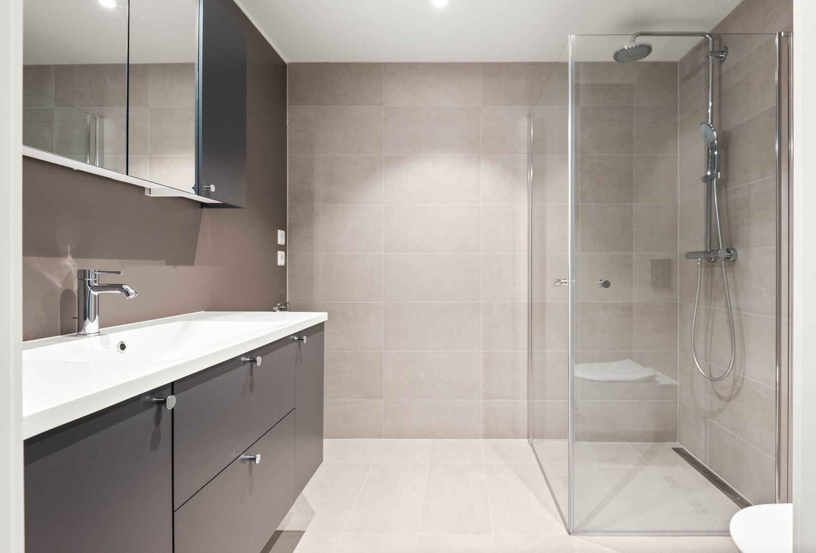 Bad nr. 2. Begge badene leveres med stilren moderne innredning fra Sigdal, og er utstyrt med takspotter som gir et behagelig lys. I tillegg har de elektriske varmekabler i gulvet. Galleribilde