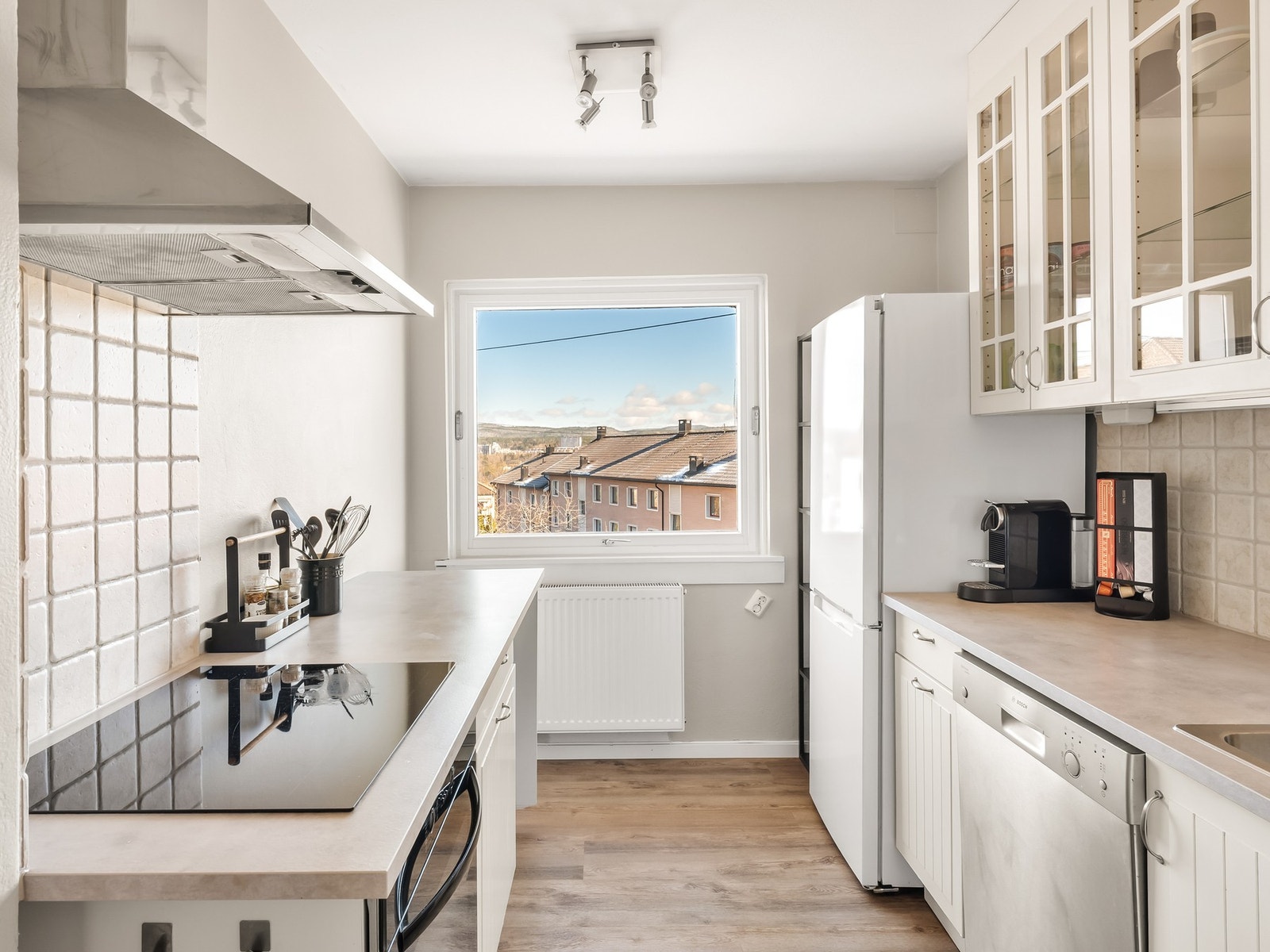 Separat kjøkken med hvite fronter, laminat benkeplate og rikelig med benke- og skapplass. Galleribilde