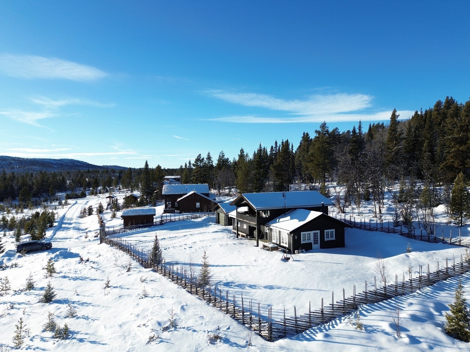 Eiendommen er omkranset av en sjarmerende skigard, som gir et autentisk preg og sikrer privatliv. Galleribilde