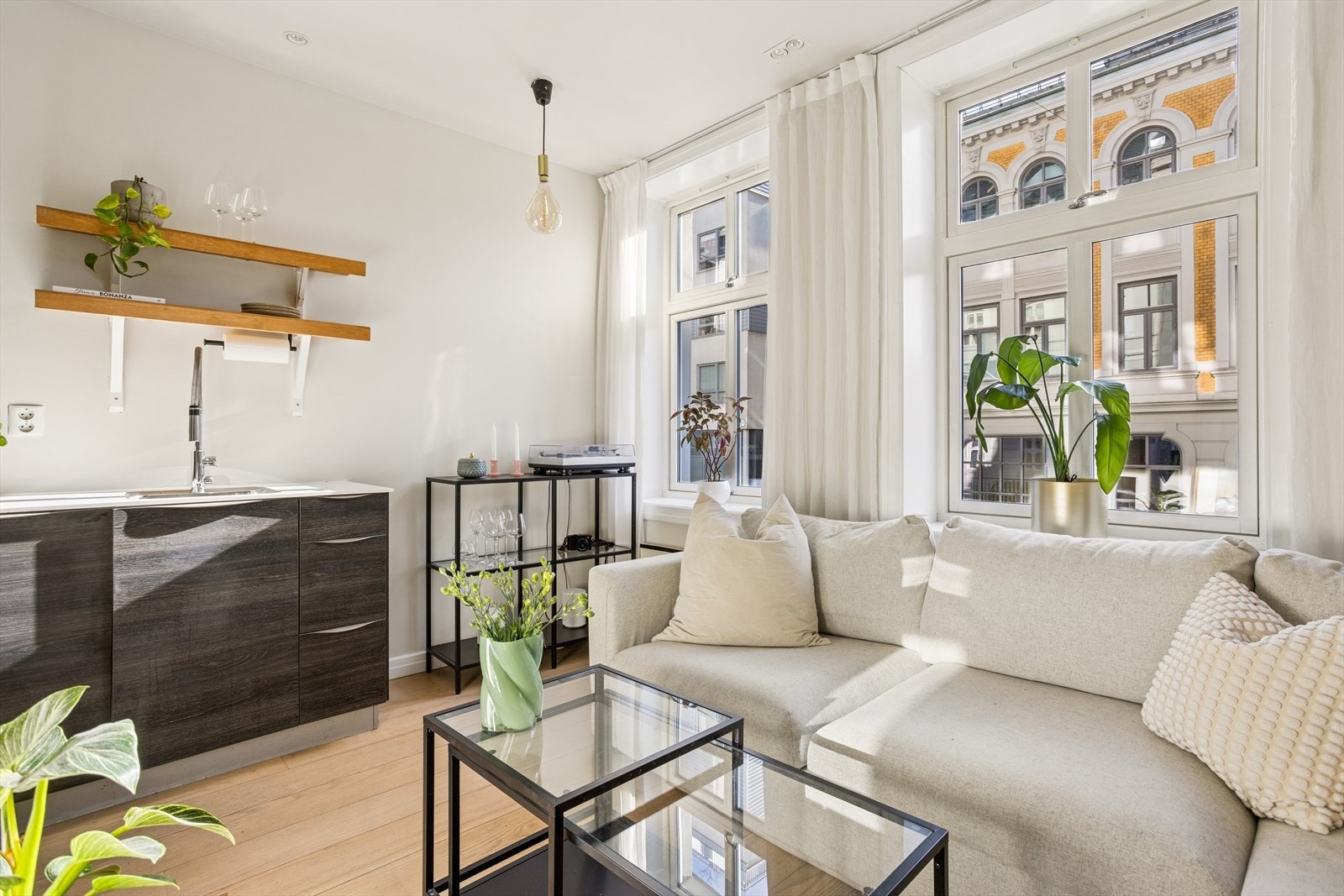 Store vindusflater på rekke og rad sørger for masse lysinnslipp i leiligheten, noe som skaper en lys og luftig atmosfære Galleribilde