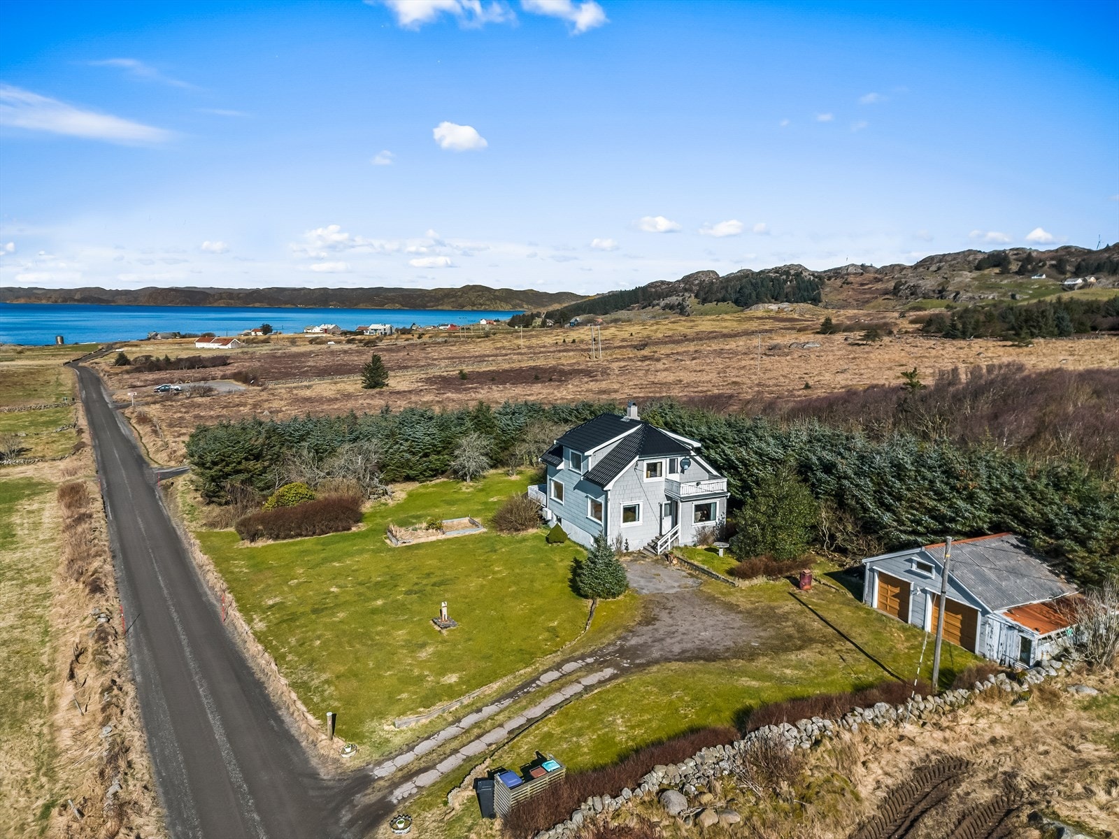 Tomta går langs steingjerdet og er innrammet med hekk mot nord og vest. Galleribilde