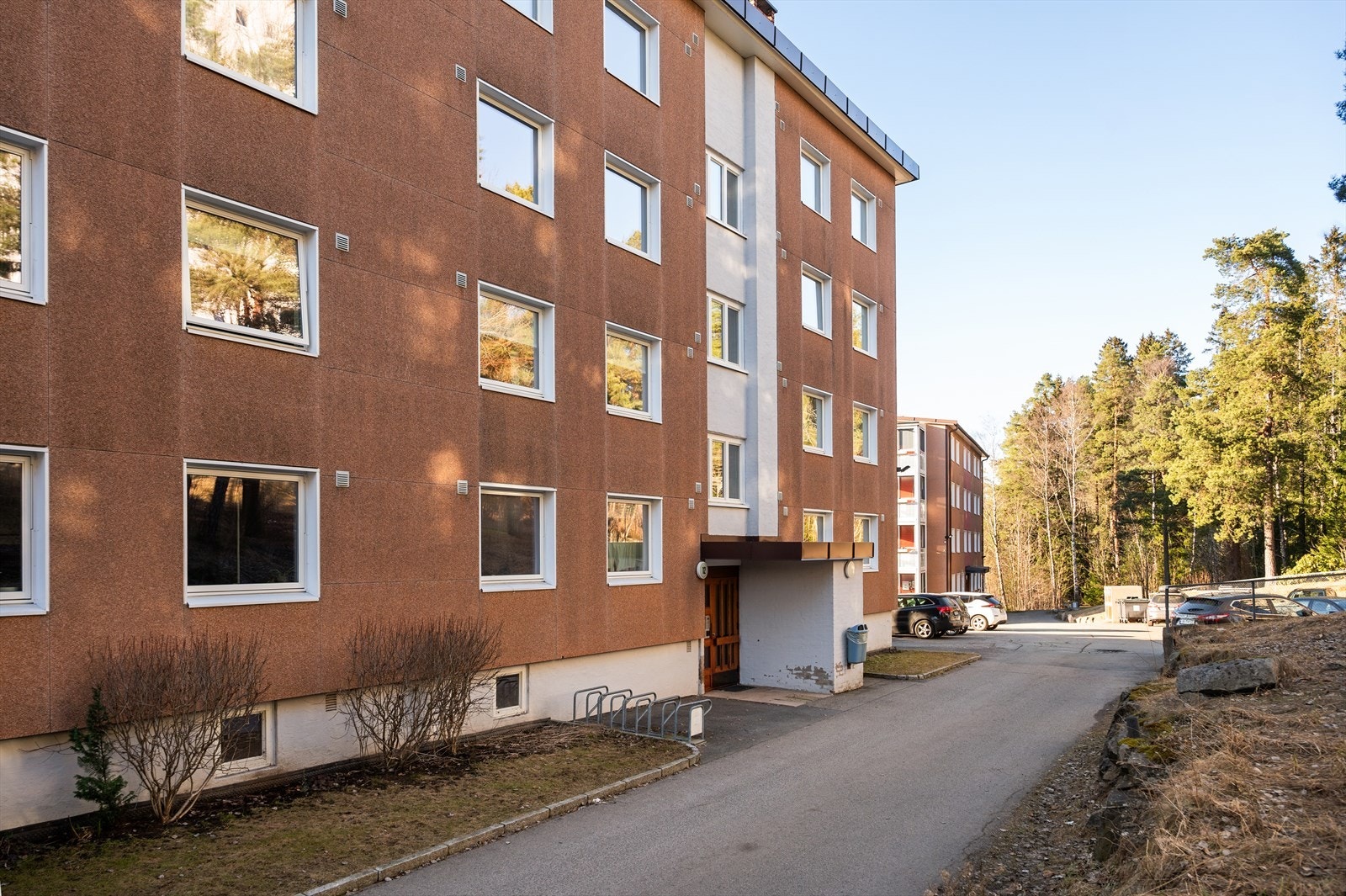 Pent opparbeidet felles tomt med plen, trær, diverse beplantning, sittebenker, lekeplass og asfalterte internveier. Galleribilde