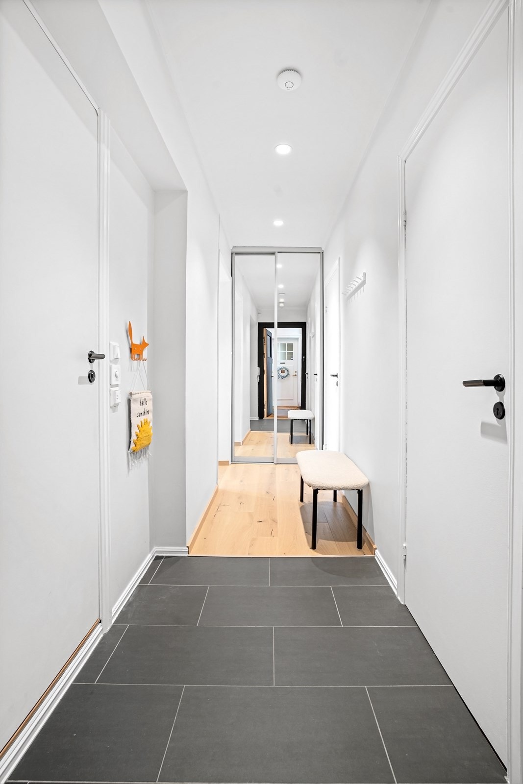Innbydende entré med plass til klesoppheng og skyvedørsgarderobe i enden. Galleribilde
