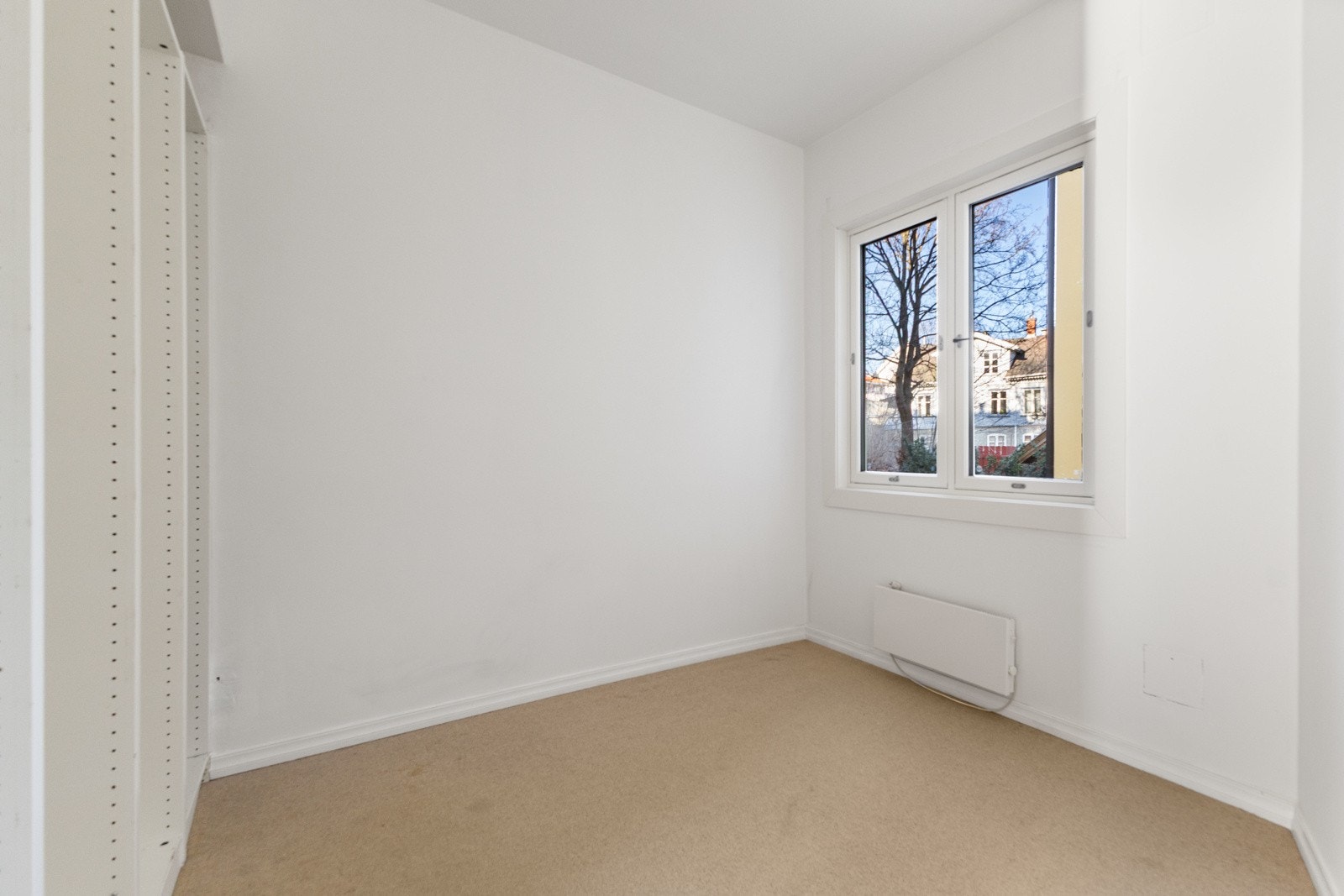 Romslig soverom som vender ut mot rolig bakgård Galleribilde