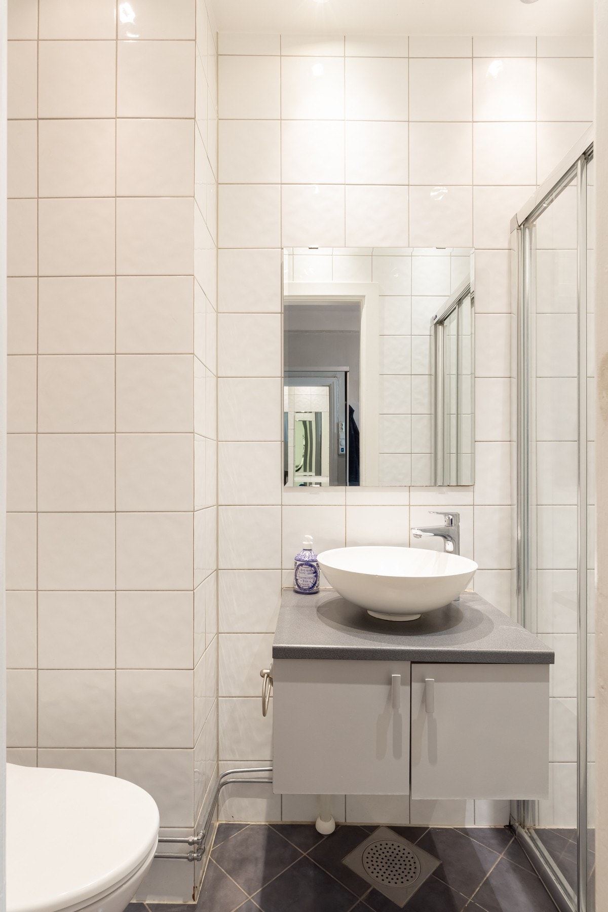 Badet er utstyrt med baderomsinnredning med benkeskap med glatte fronter og speil over servant. Galleribilde