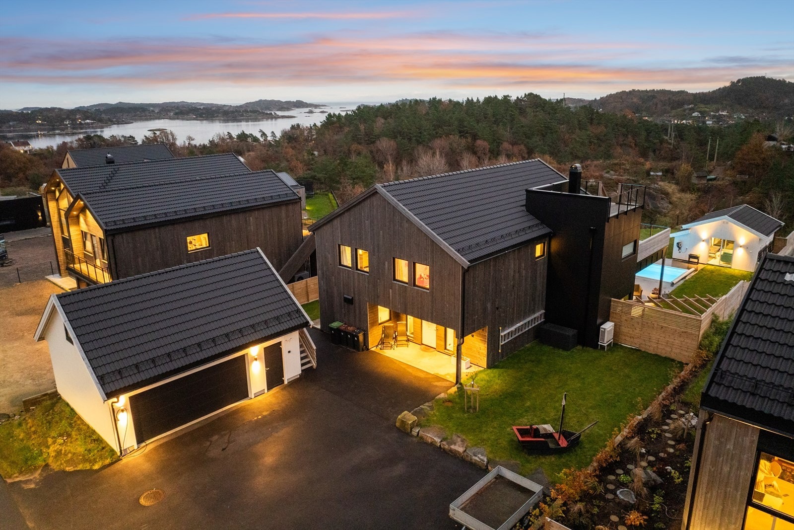 Asfaltert gårdsplass med god plass til flere biler, samt frittstående dobbel garasje med loft Galleribilde