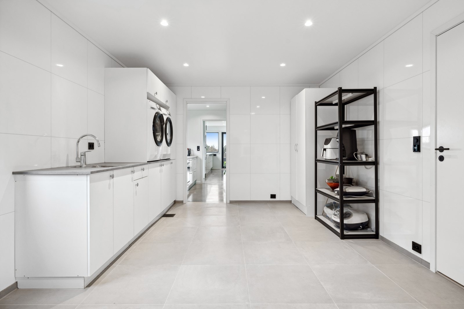 Meget romslig vaskerom med flotte fliser på gulvet og baderomsplater på gulvet Galleribilde