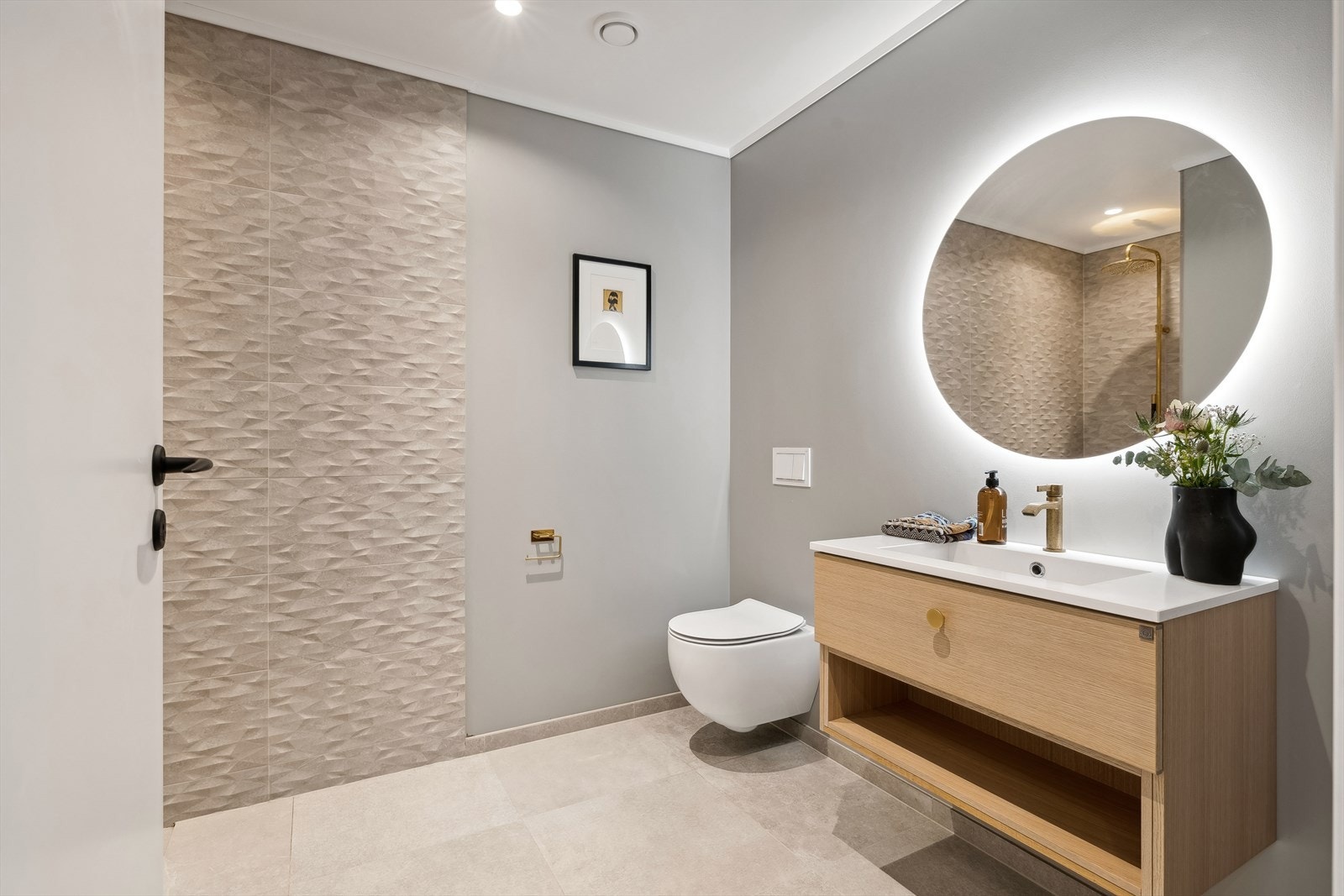 Delikat baderom i 1. etasje med moderne fliser på gulv og i dusjhjørnet. Galleribilde