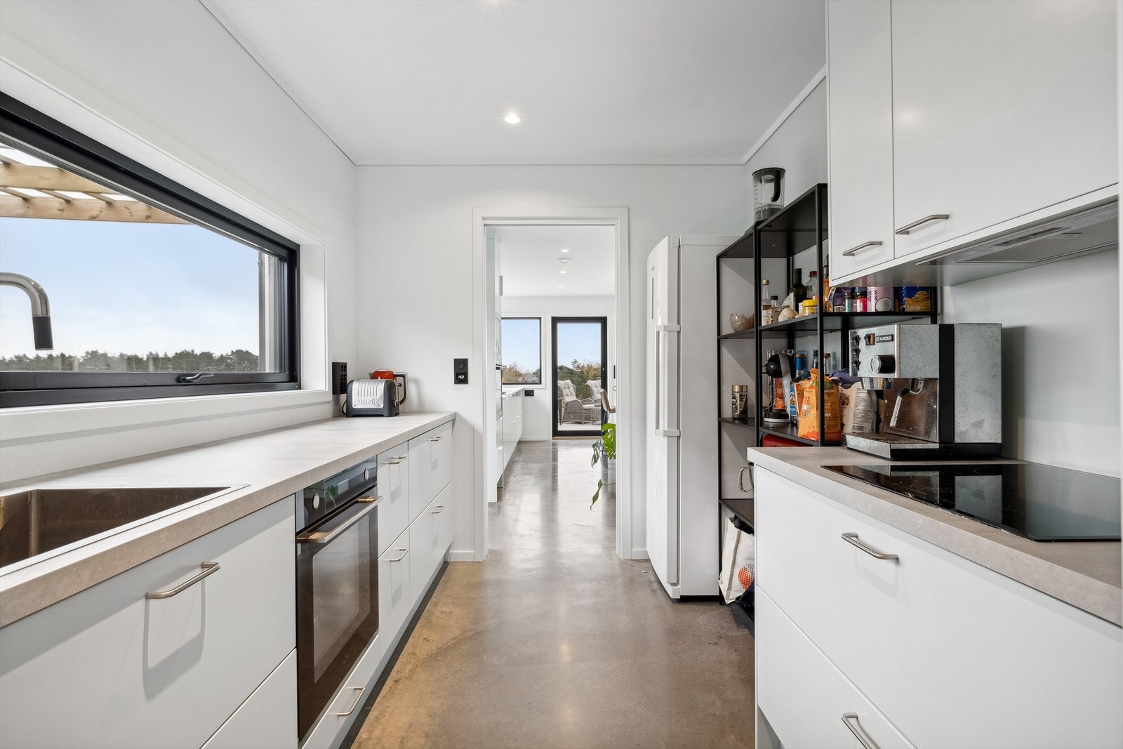 Et meget praktisk grovkjøkken med integrerte hvitevarer som stekeovn og platetopp. Galleribilde