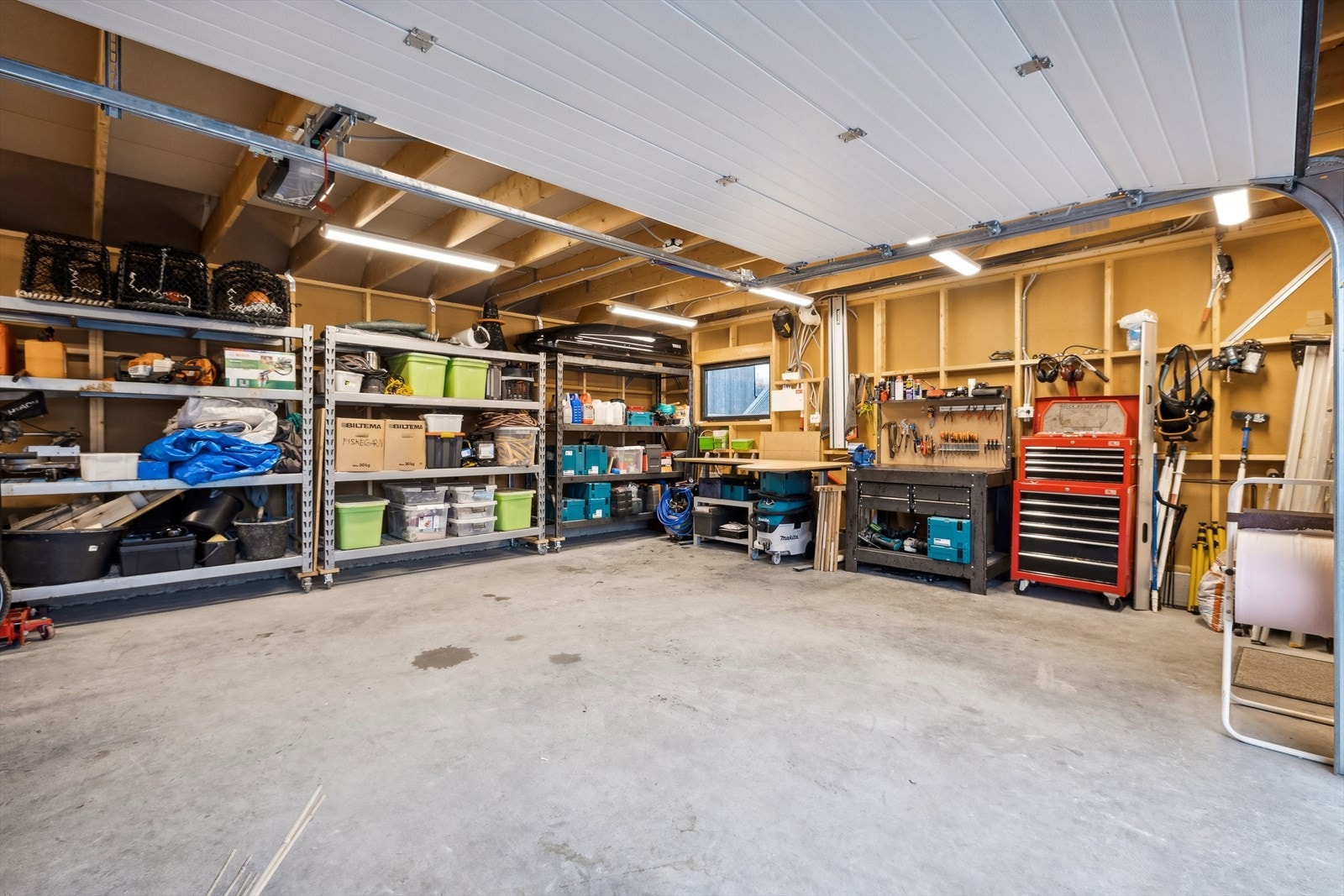 Den doble garasjen rommer både to biler og hyller for oppbevaring Galleribilde