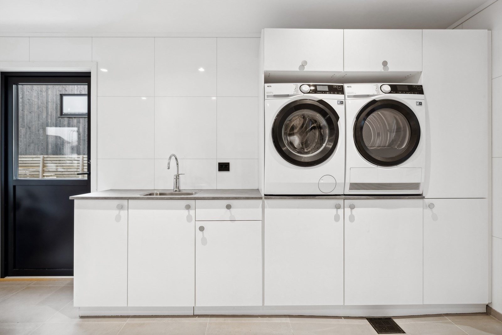 Vaskerommet er innredet med god skapplass og opplegg til vaskemaskin og tørketrommel i riktig arbeidshøyde Galleribilde