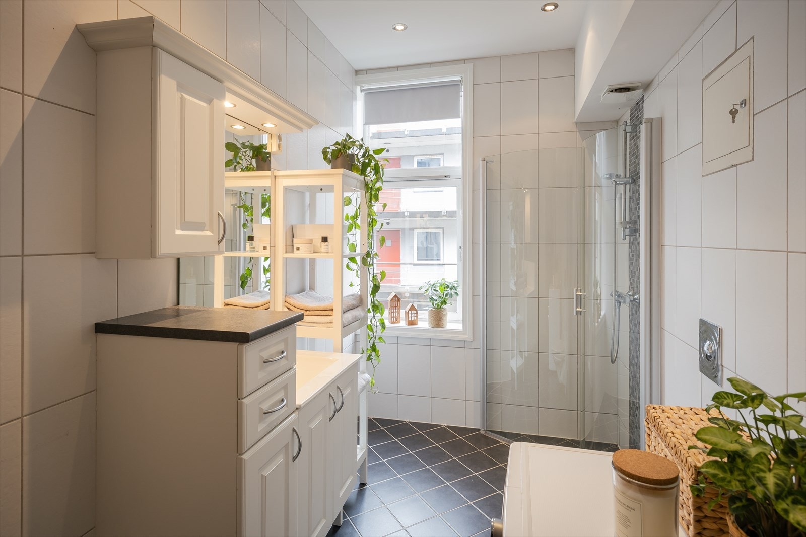 Badet er utstyrt med innfellbare dusjdører, varmekabler i gulvet og opplegg for vaskemaskin. Galleribilde