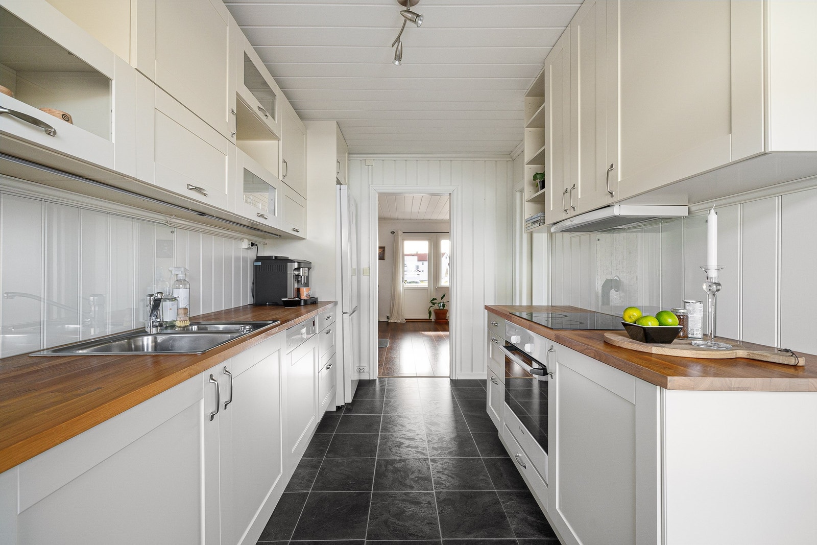 Motstående vask og platetopp omgitt av arbeidsflater gjør kjøkkenet praktisk i daglig bruk. Galleribilde