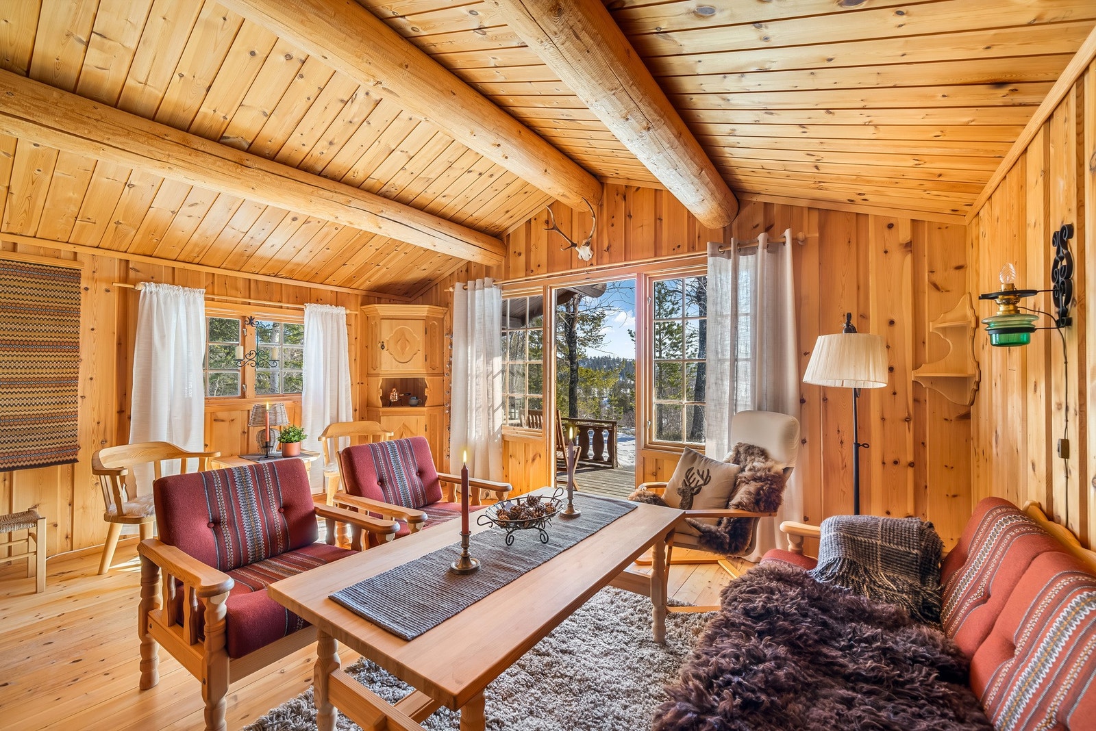 Stua er åpen og koselig, med panel på vegger og i himling Galleribilde