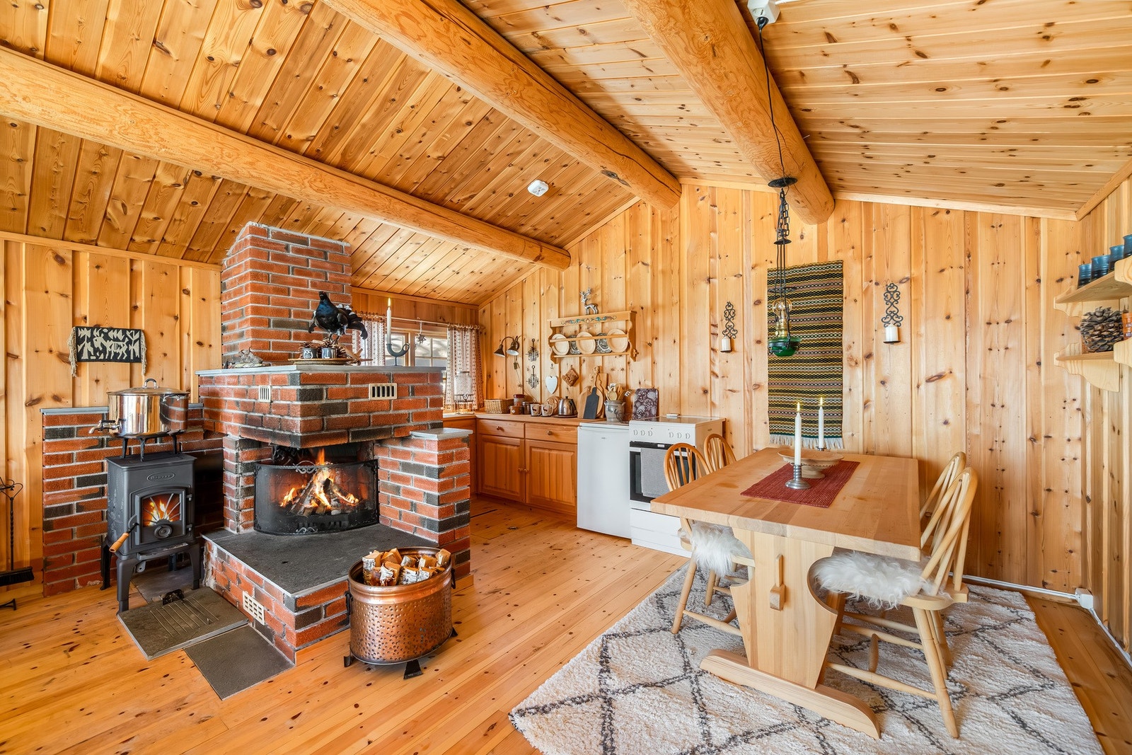 Peisen som er muret opp i tegl, danner vegg mot kjøkkenet og deler opp rommet Galleribilde