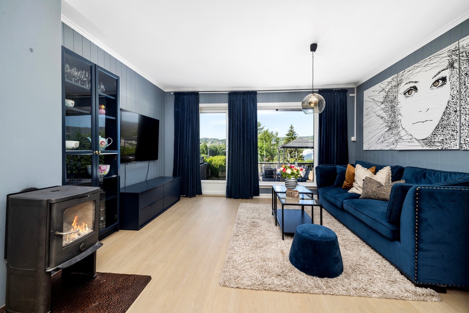 Stue med koselig peisovn og med utgang til terrasse. Galleribilde