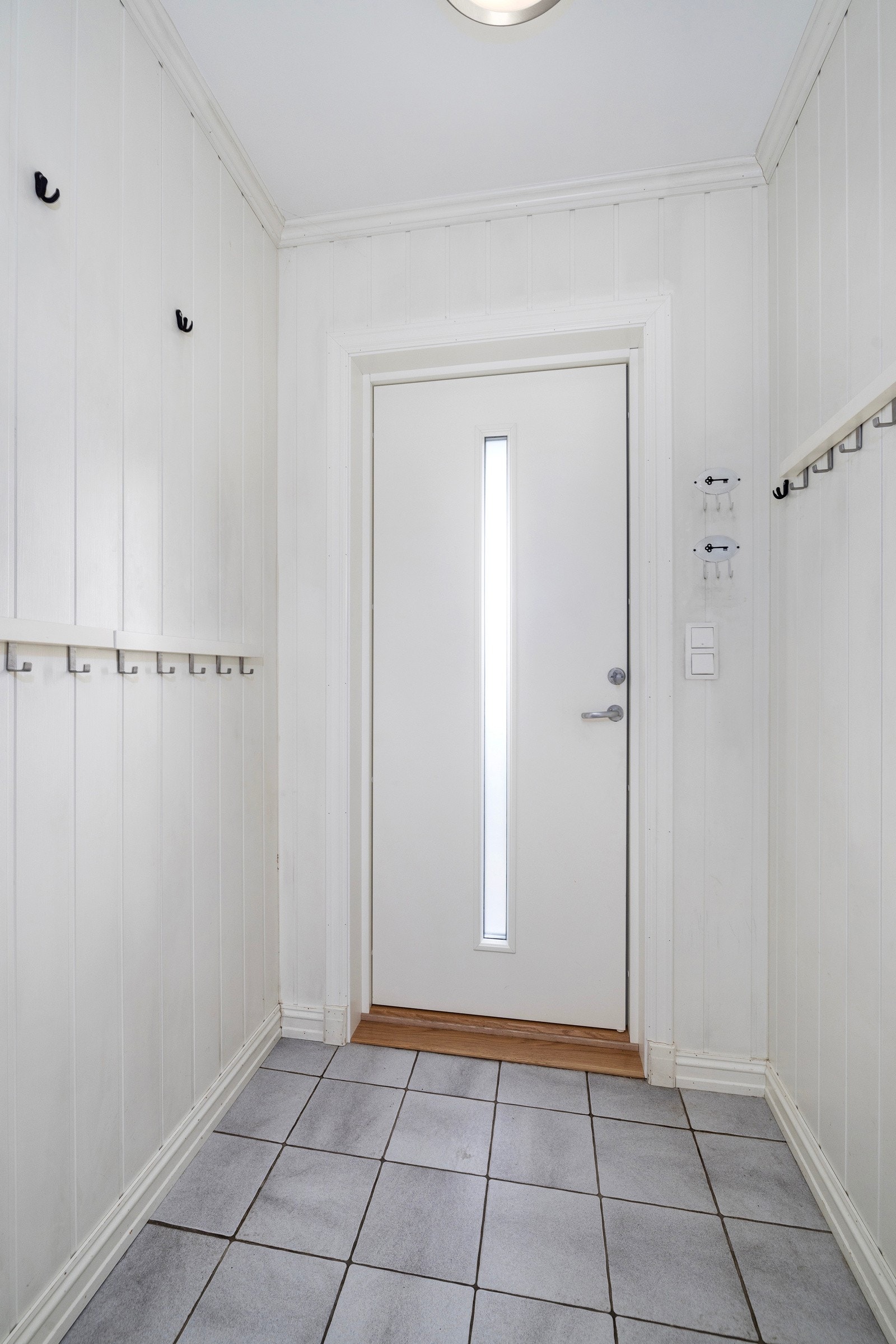 Lys entré med flislagt gulv. Galleribilde