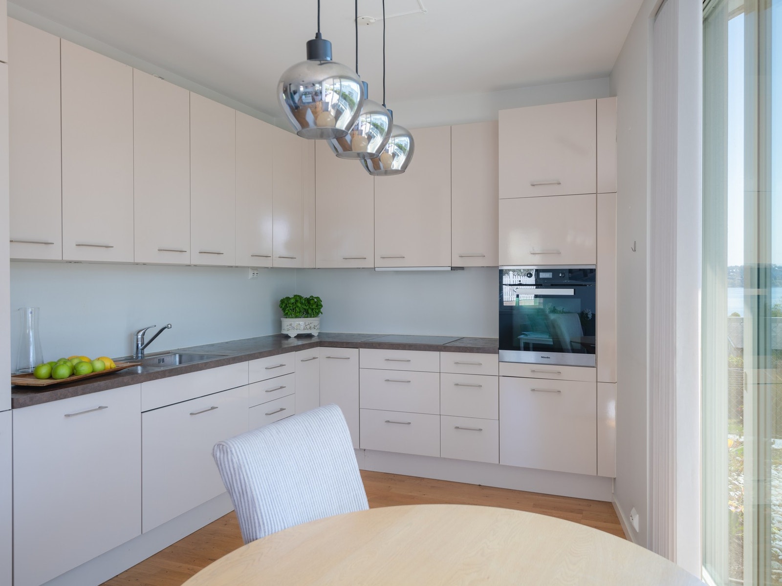 Kjøkkenet har slette fronter og laminat benkeplate. Integrert komfyr, induksjonstopp, kjøl/fryseskap og oppvaskmaskin. Galleribilde