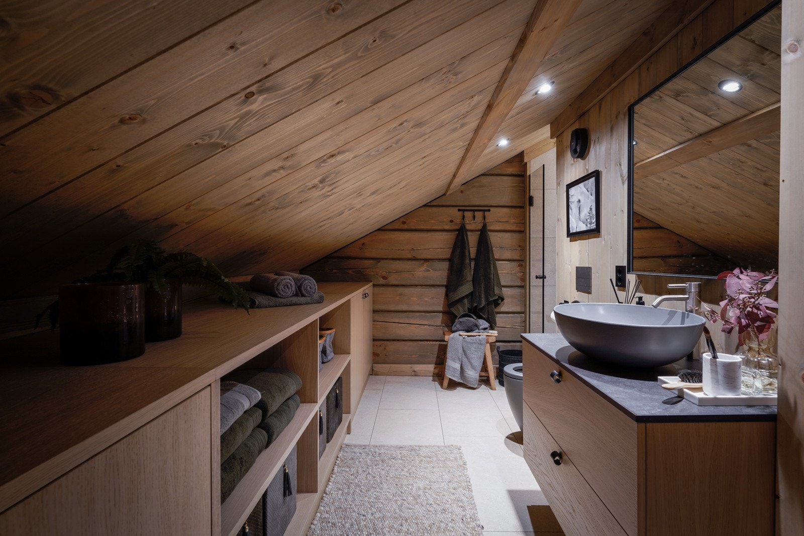 Bad i loftsetasjen med fliser på gulv. Veggene har flis i dusjsona, forøvrig tømmervegger. Galleribilde