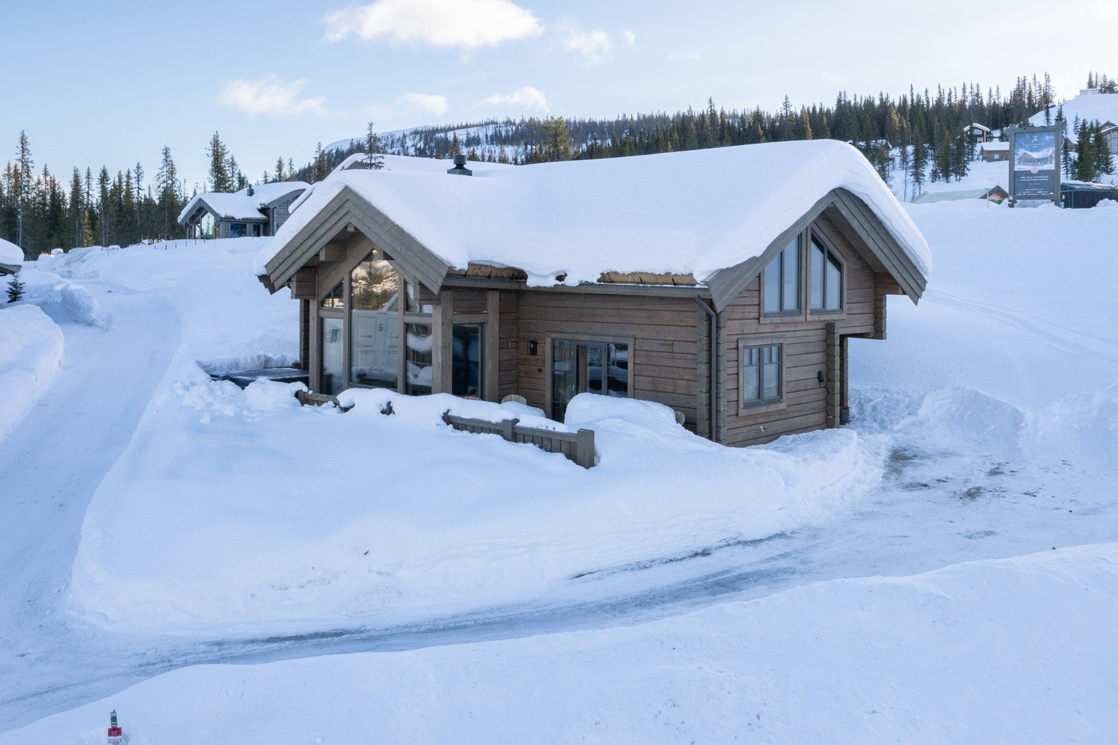 Hytta ligger pent tilbaketrukket på toppen av en skråning, med fine utearealer i bakkant av hytta. Galleribilde