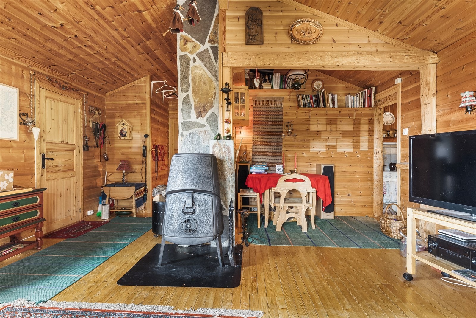 Innvendig har hytten panel og rundtømmer på vegger, samt en blanding av furugulv og skiferstein på gulv. Galleribilde