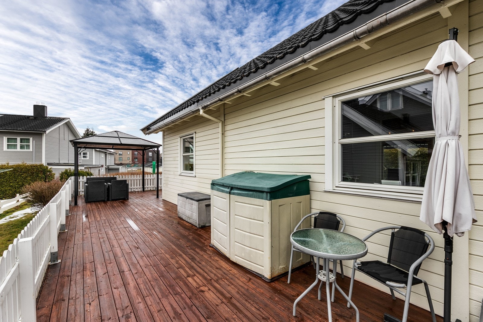 Terrassen strekker seg helt fra inngangssiden og rundt tilbygget med stuen. Galleribilde