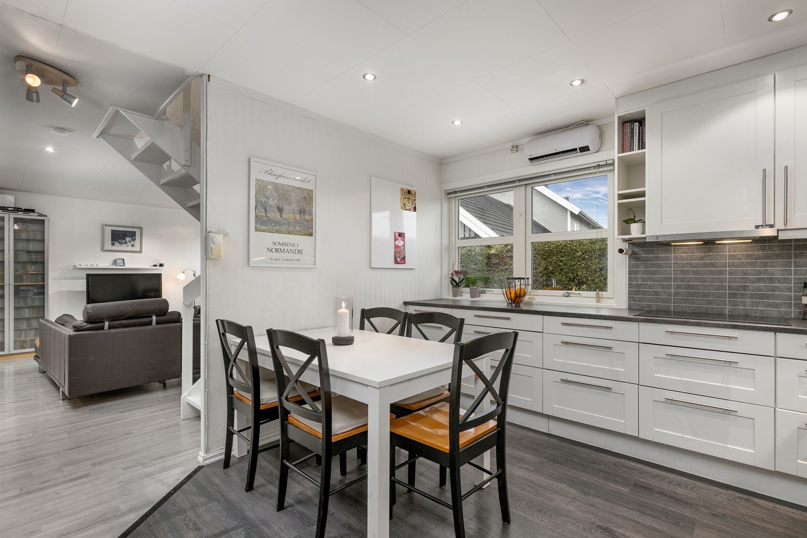 God plass til koselig spisebord ved det store vinduet som slipper inn rikelig med naturlig sollys. Det er montert elektrisk vifteovn på vegg over vinduet. Galleribilde