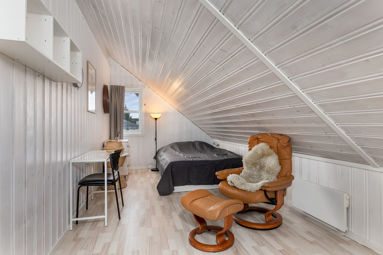 Innredet rom 1 har panelte vegg- og himlinger, sjarmerende skråtak, laminat på gulv, samt vindu med flott utsyn over nærområdet. Galleribilde