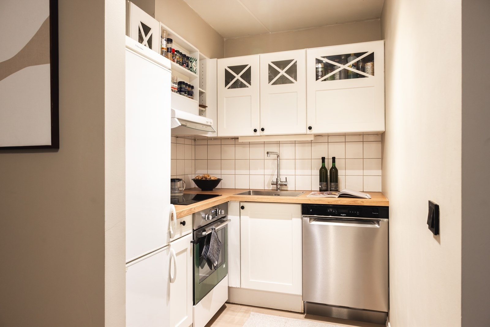 - Kjøkkeninnredning med profilerte fronter, heltre benkeplate med nedfelt vaskekum og fliser og belysning over benkeplaten - Galleribilde