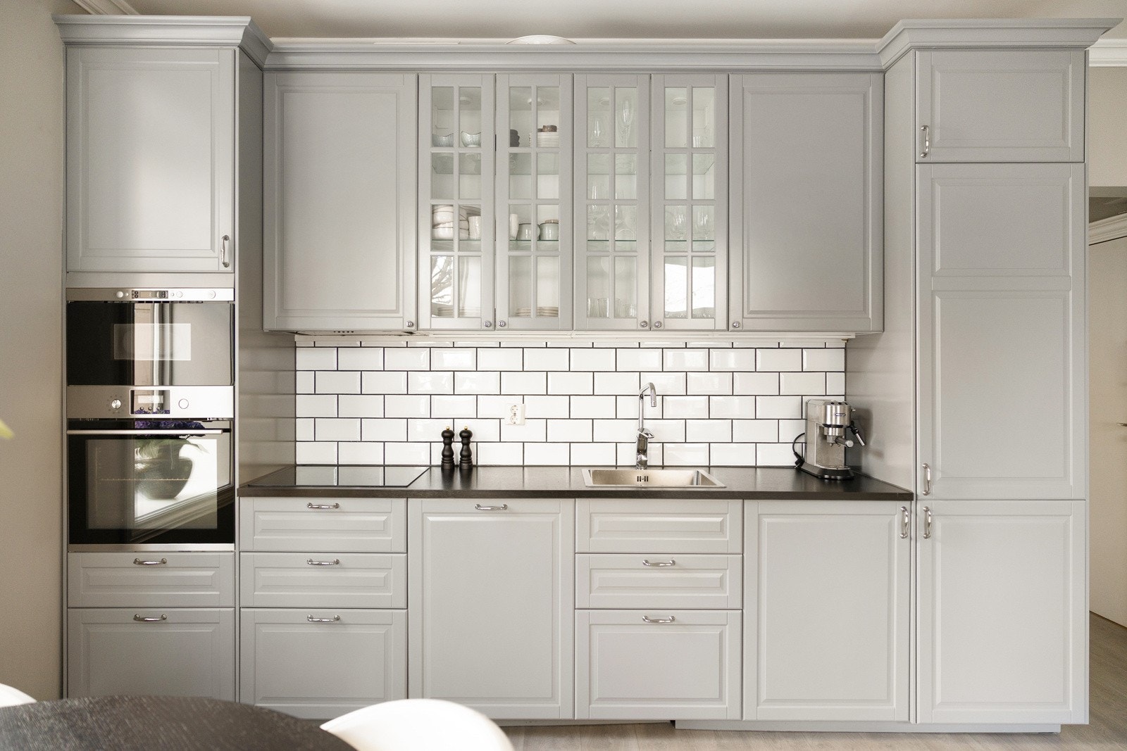 Tidløst og funksjonelt kjøkken med integrerte hvitevarer. Fliser på veggen gir et klassisk preg. Galleribilde