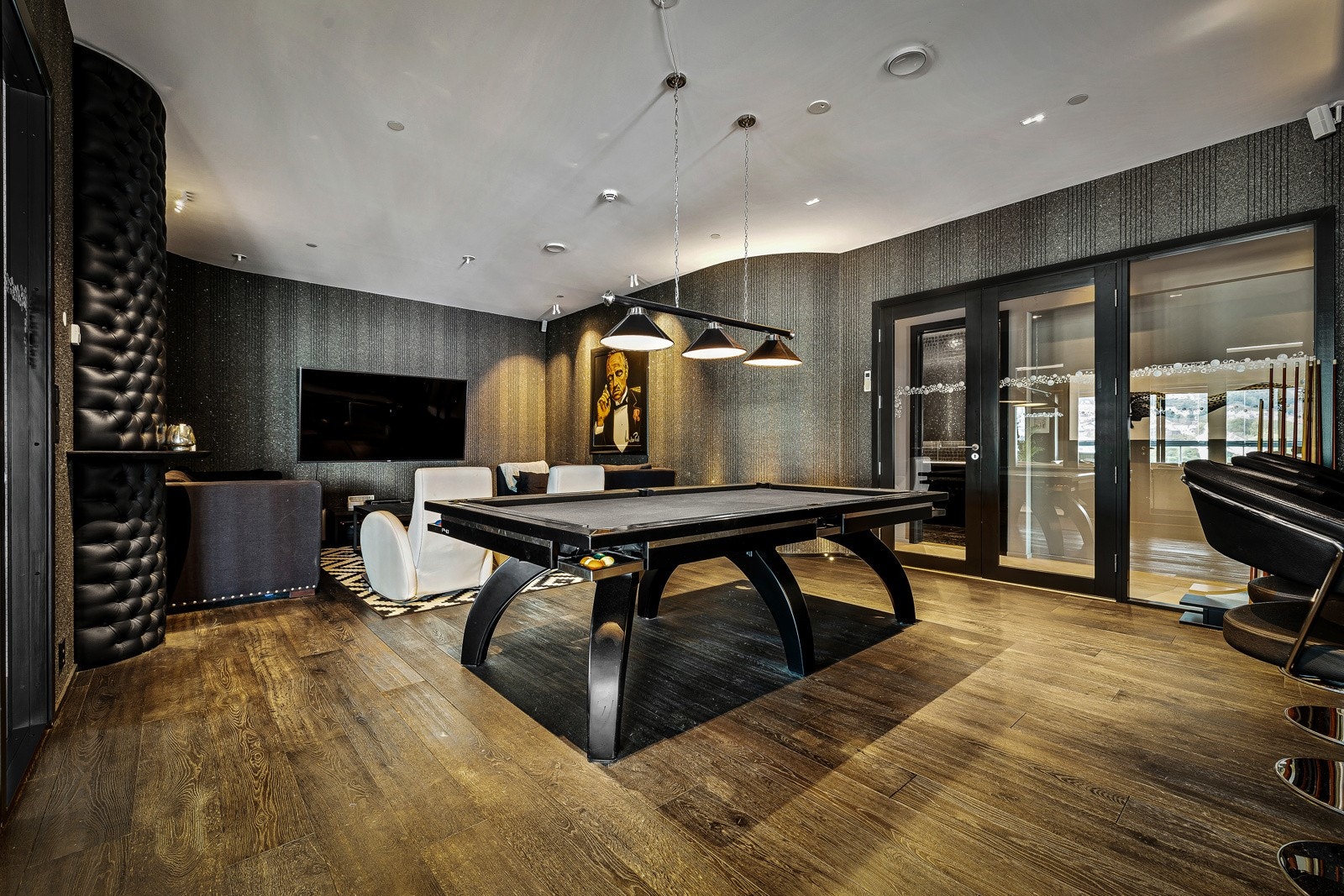 Boligen har et stort medierom med bar, som et lukket midtpunkt i leiligheten Galleribilde