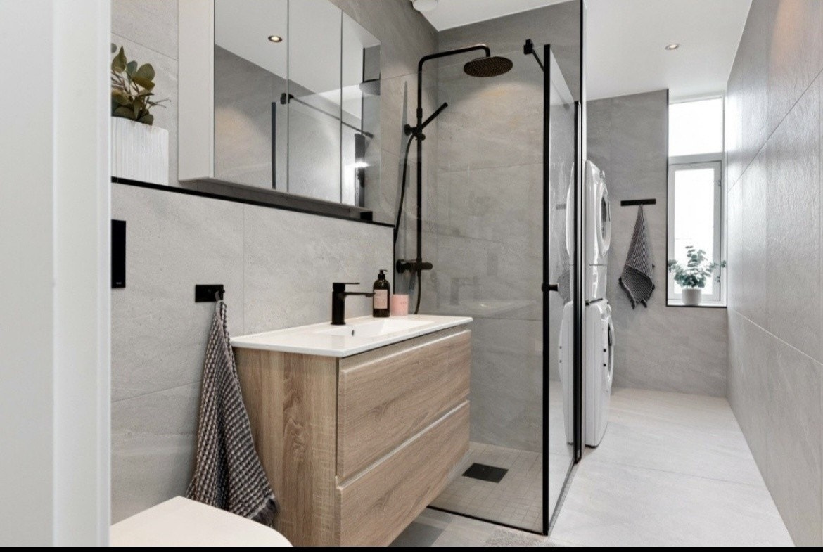 Lyst og luftig bad med alt du trenger av hvitevarer Galleribilde