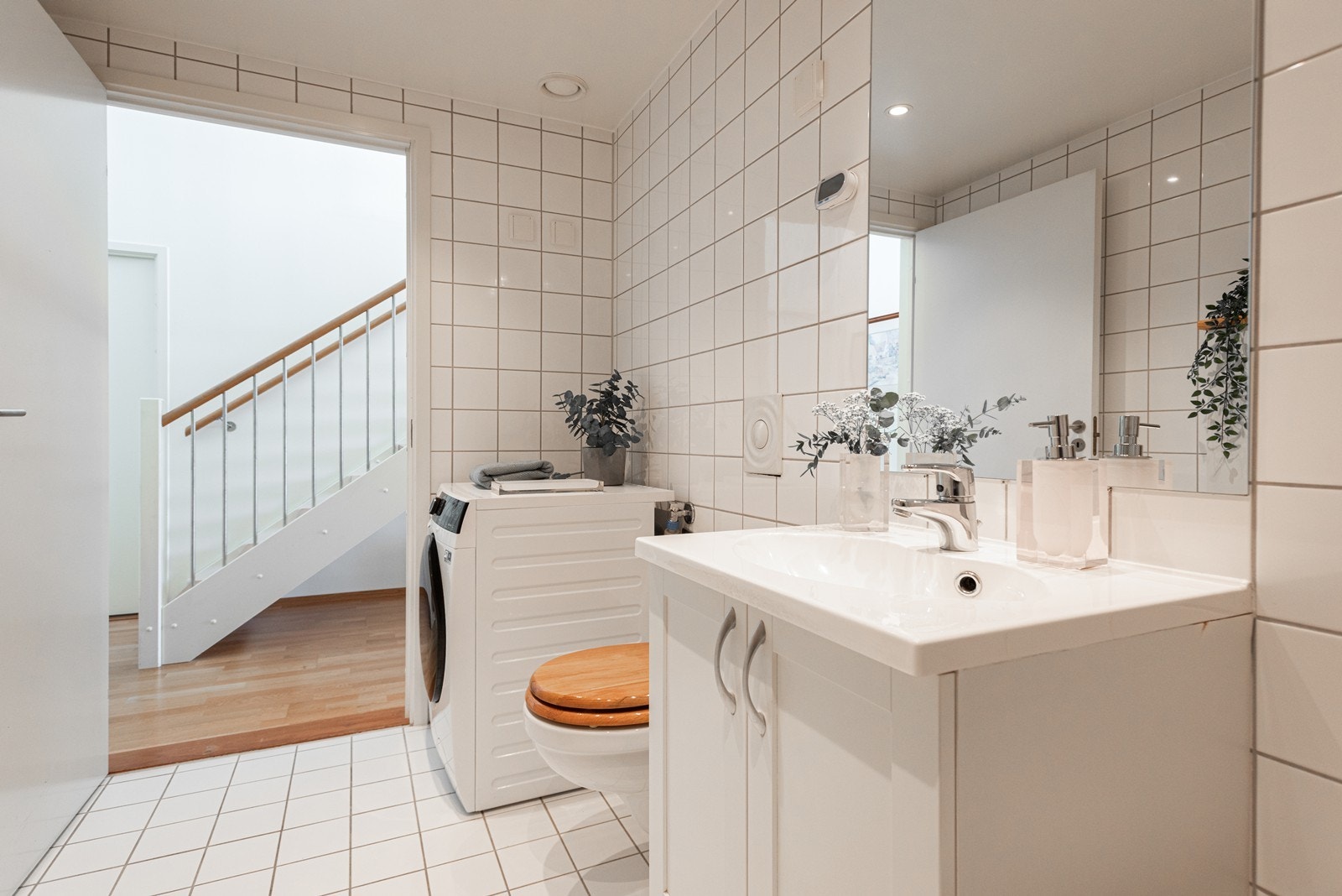 Baderommet har innredning med nedfelt servant og skapdører, veggmontert toalett, innfliset badekar og opplegg for vaskemaskin. Spotlights i tak. Galleribilde