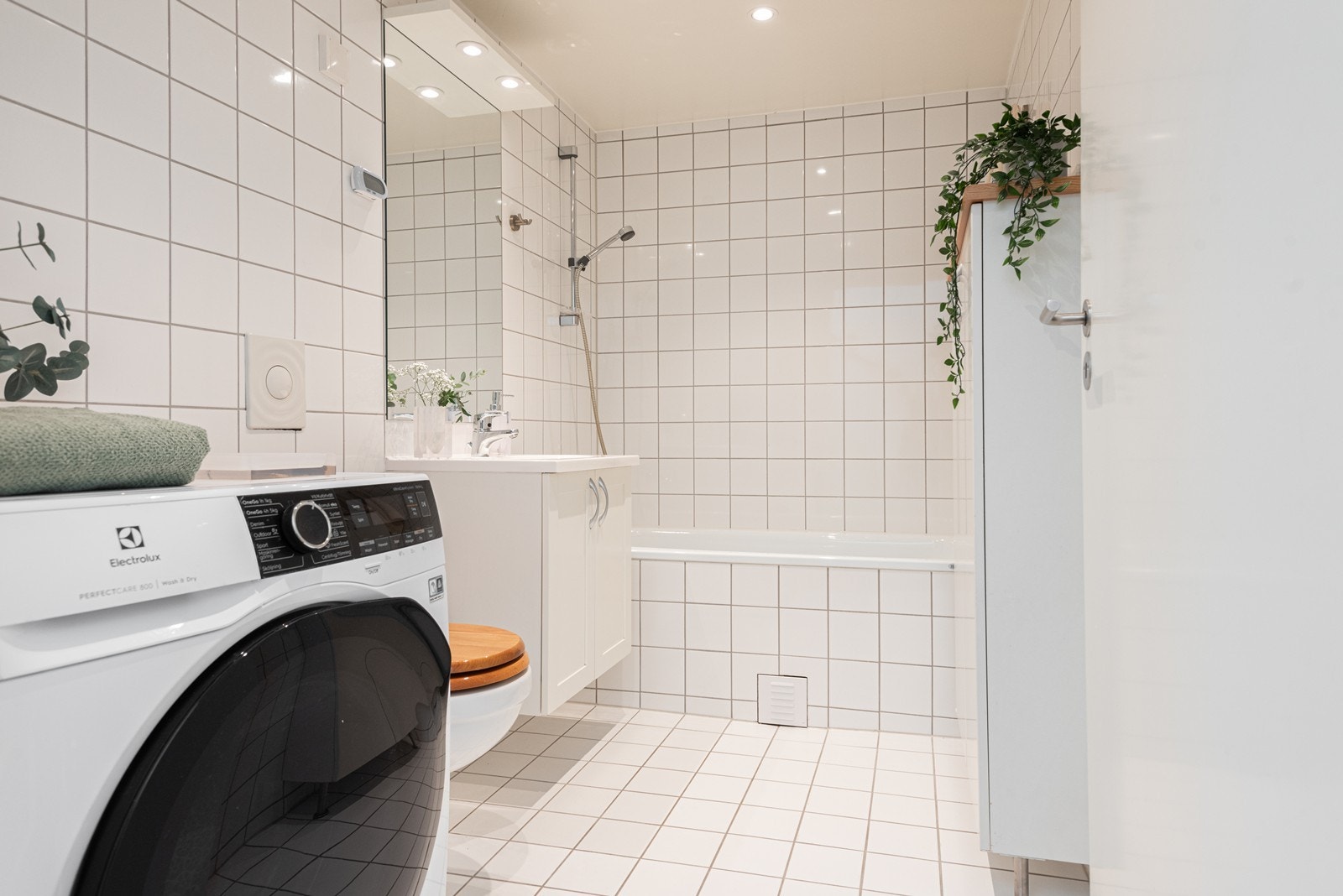 Ett av leilighetens to bad. Badekar og opplegg for vaskemaskin. Galleribilde