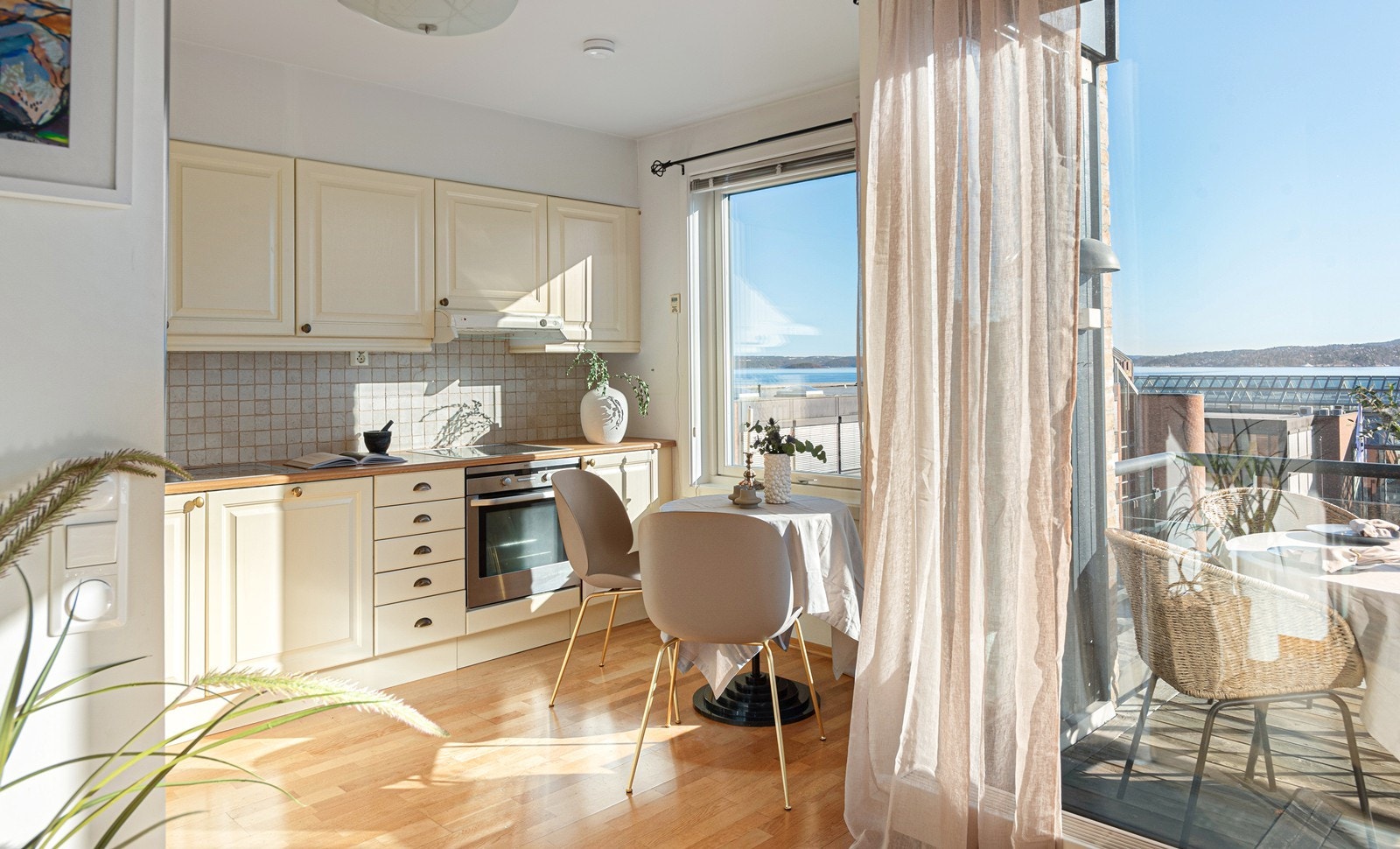 Kjøkken med integrerte hvitevarer, heltre benkeplate og fliser over kjøkkenbenk Galleribilde