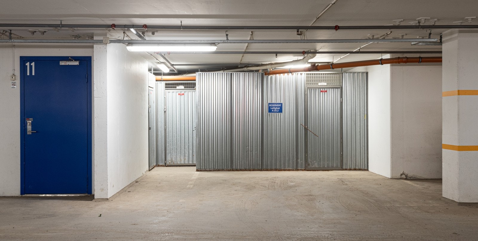 Stor garasjeplass og bod, med inngang til heis rett ved siden av. Galleribilde