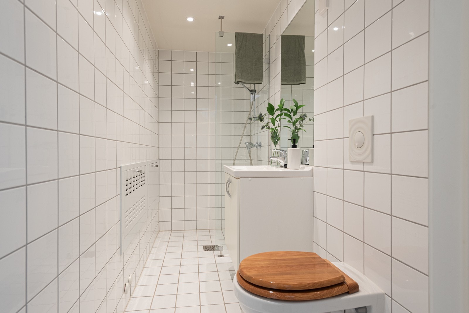 Bad nr. 2 med 15*15 fliser, innredning med nedfelt servant, to skapdører, ettgreps blandebatteri og speil over vasken. Veggmontert toalett. Galleribilde