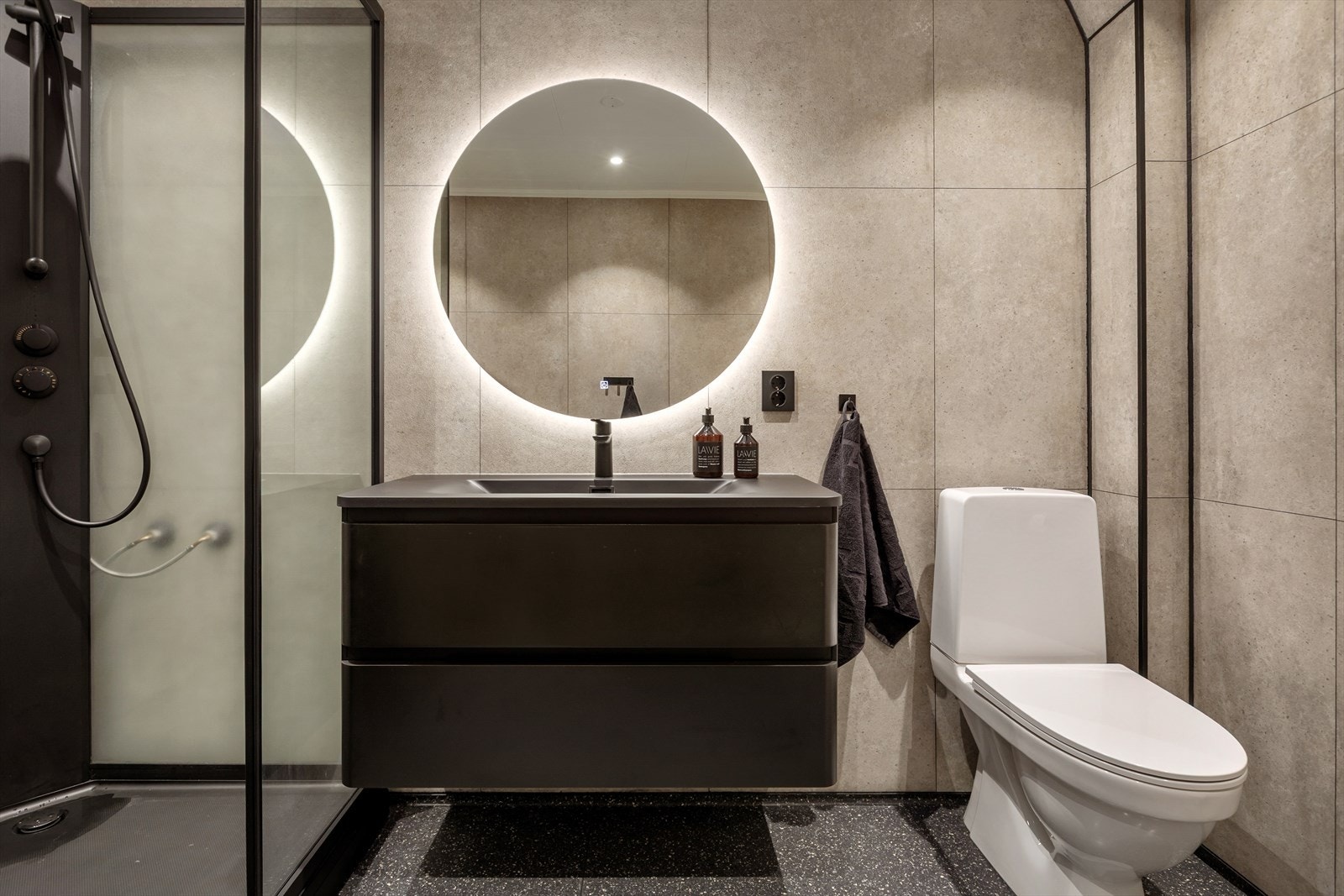 Badet har et moderne preg med sorte detaljer Galleribilde