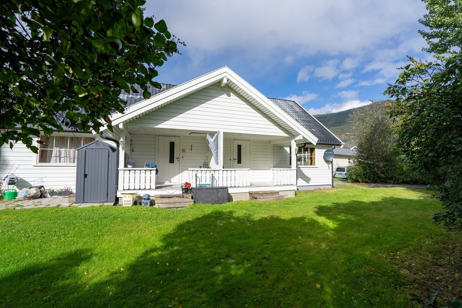 Flat tomt med plen og biloppstillingsplass. Galleribilde