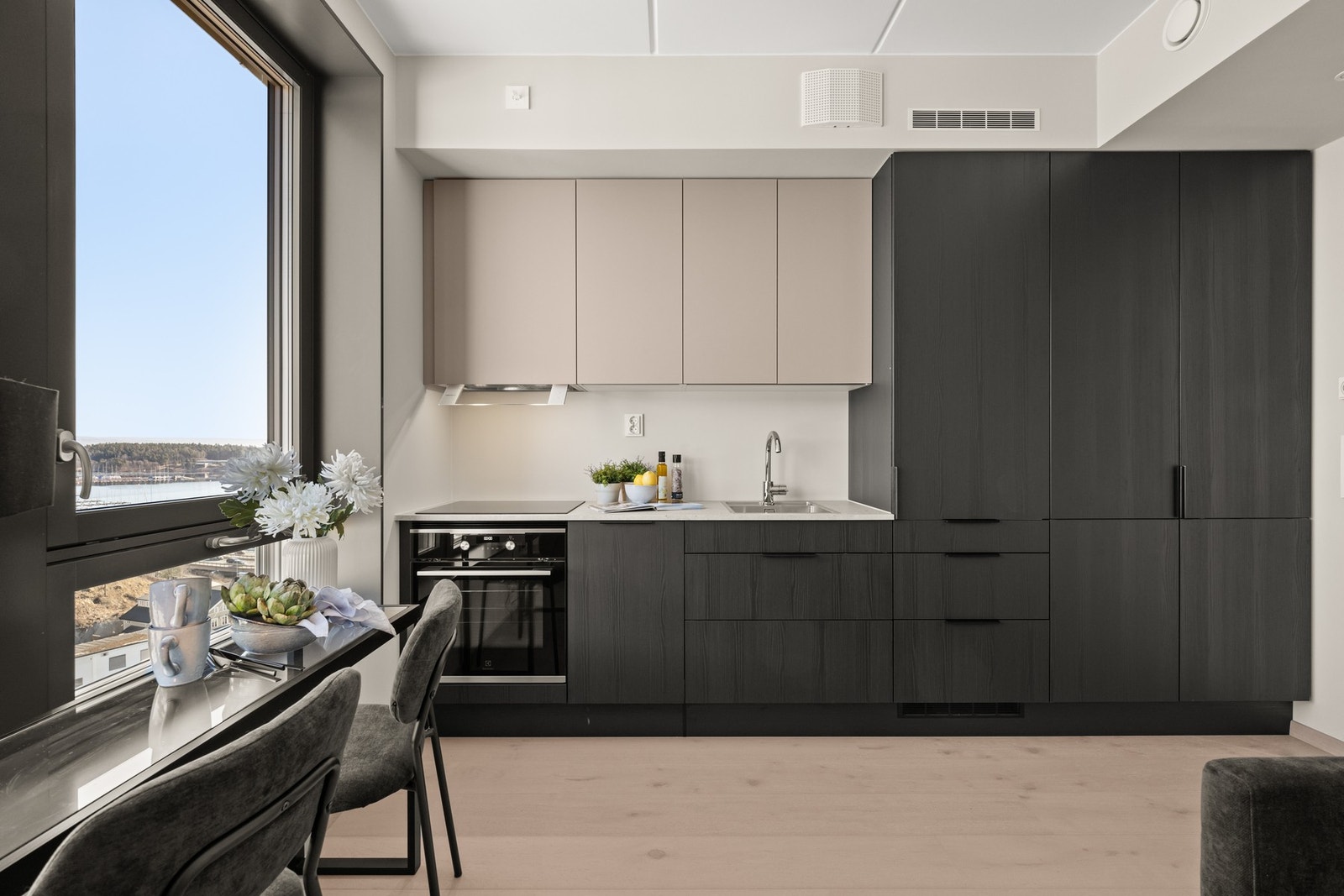 Kjøkkenet er levert av HTH og har stilrene, slette fronter i to harmonerende fargetoner, som skaper et elegant og sofistikert uttrykk Galleribilde